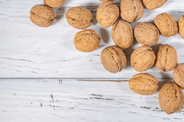 Beyaz ahşap masadaki ceviz çekirdekleri, stok fotoğrafı