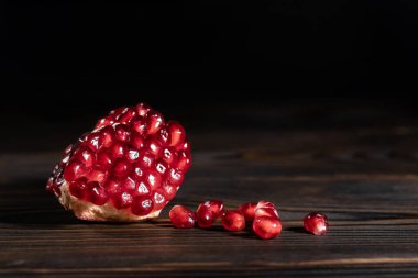 Kraklenmiş olgun nar, koyu ahşap arka planda.