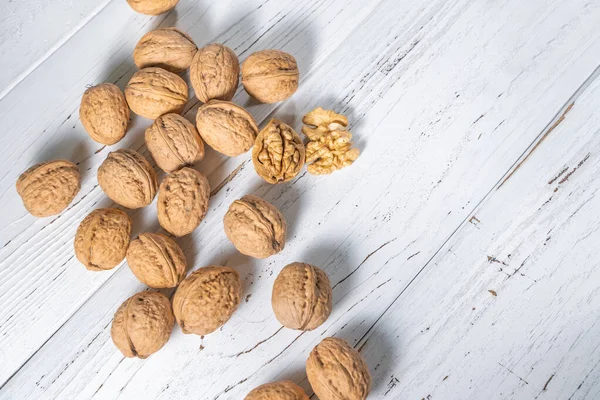 Beyaz ahşap masadaki ceviz çekirdekleri, stok fotoğrafı