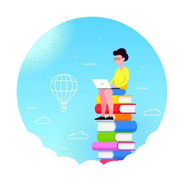 Genç adam dizüstü bilgisayarla kitap yığınının üzerinde oturuyor.