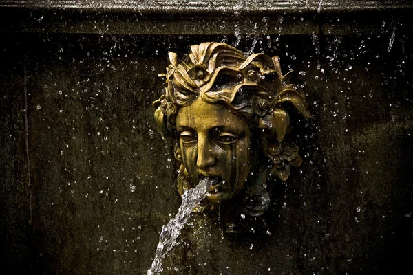 Bronze face on a fountain