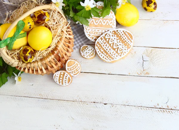 Цветные пасхальные печенья на белом деревянном фоне — стоковое фото