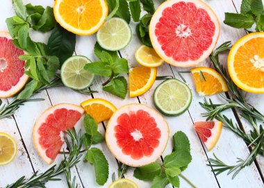 Dilimlenmiş narenciye limon, limon, portakal, greyfurt ahşap arka plan üzerine nane ile kümesi