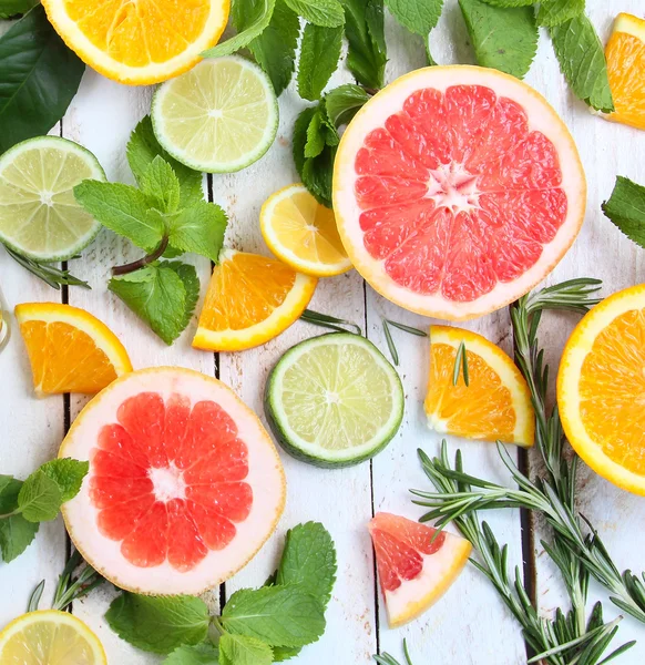 Set gesneden citrusvruchten lemon lime, oranje, grapefruit met munt over houten achtergrond — Stockfoto