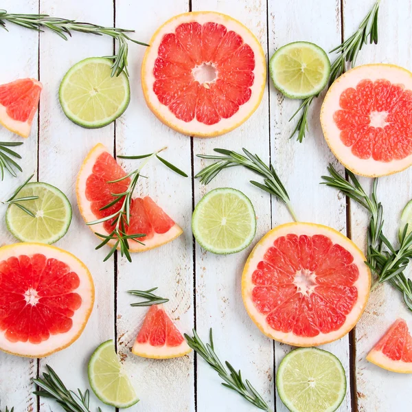 Set of sliced citrus lemon, lime, grapefruit, mint and rosemary on wooden background — Stock Photo, Image