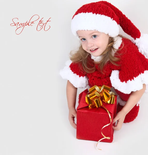 Cute little girl in a New Year's cap with a gift — Stock Photo, Image