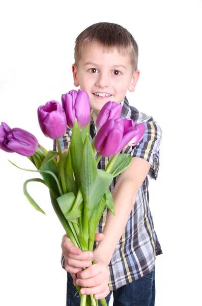 笑みを浮かべて少年を伸ばすピンクのチューリップの前方の花束 — ストック写真