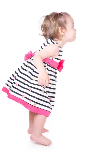 Happy little girl peeking out from behind a white advertisement board — Stock Photo, Image