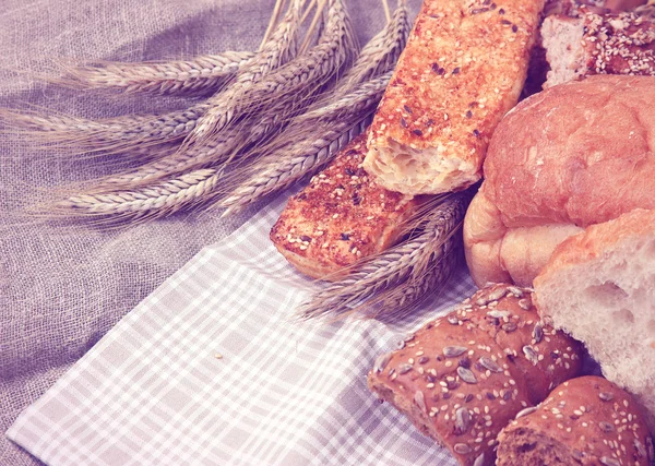 나무 위에 놓인 신선 한 빵과 밀 — 스톡 사진