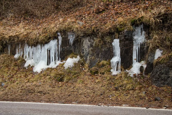 Dolomite 'nin ortasında bir dağ yolunun yanında buz sarkıtları var.