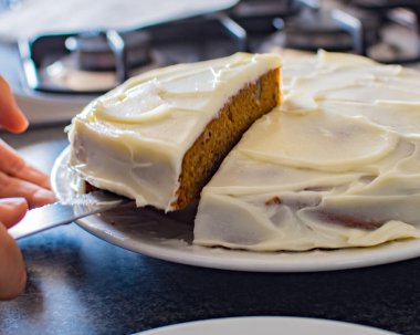 Tanınmayan eller lezzetli ve lezzetli bir parça havuçlu kek topluyor.