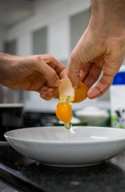 Tanımlanamayan eller havuçlu kek hazırlamak için yumurta kırıyor.