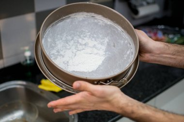 Kekin yapışmasını önlemek için tanınmaz hale gelmiş eller.