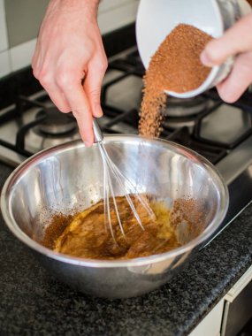 Tanınmayan eller havuçlu kek hazırlamak için şeker atıyor.