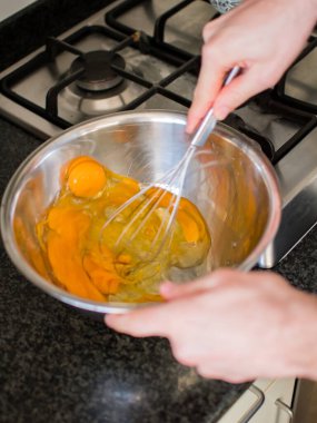 Tanınmayan eller havuçlu kek hazırlamak için yumurta çırpıyor.