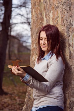 Üniversite kız parkta bir kitap okuma