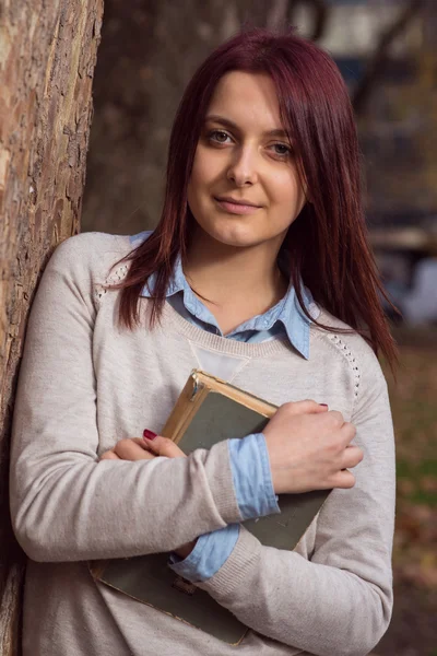 Universitet girl i park läser en bok — Stockfoto