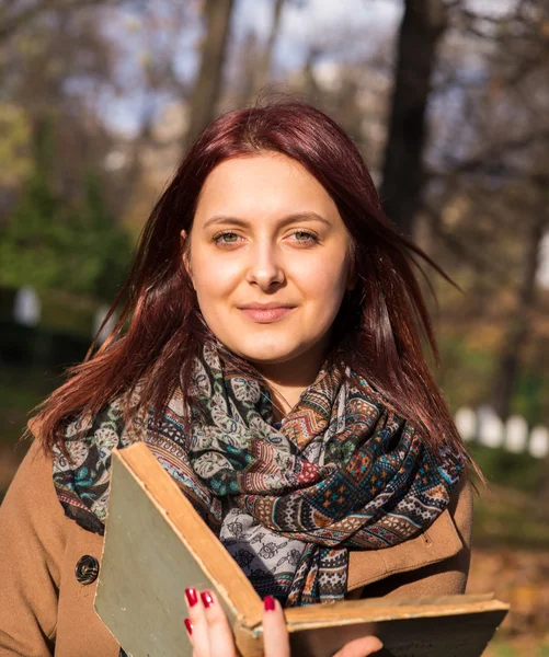 Redhead girl reading book in park — Stock Photo, Image