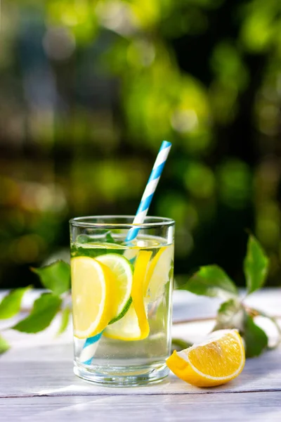 Стакан холодного лимонада с соломинкой. Прохладный напиток в летний солнечный день — стоковое фото