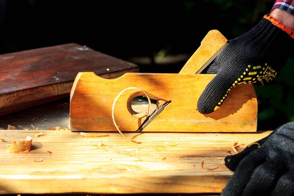 Beautiful curly shavings in a wooden plane when processing wood. Grandpa works in a carpentry workshop — Stock Photo, Image