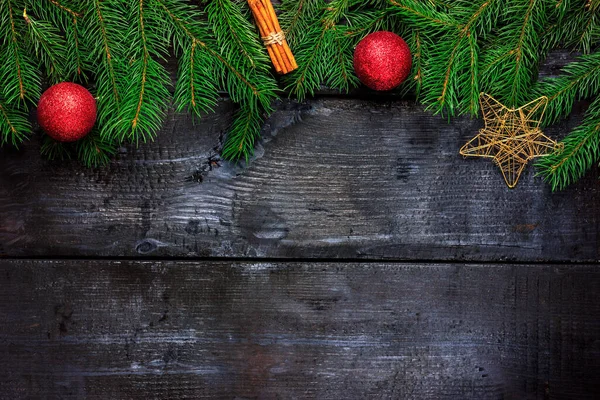 用肉桂棒和圣诞球在一棵黑树上的枞树枝条。从上面看装饰框架 — 图库照片