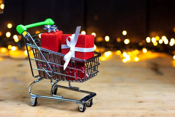 Carrinho de compras com caixas, presentes. Compras para o Natal, Black Friday, Ação de Graças. — Fotografia de Stock