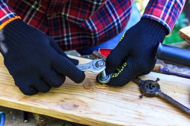 Adam somunu ingiliz anahtarıyla söküyor. Eski moda.