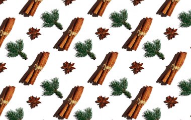 Tarçın çubukları, ladin dalları ve beyaz arka planda yıldız anason. Noel deseni