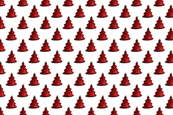 Yılbaşı ağacı desenli parlak bir oyuncaktan beyaz arka planda kırmızı bir Noel ağacı şeklinde.