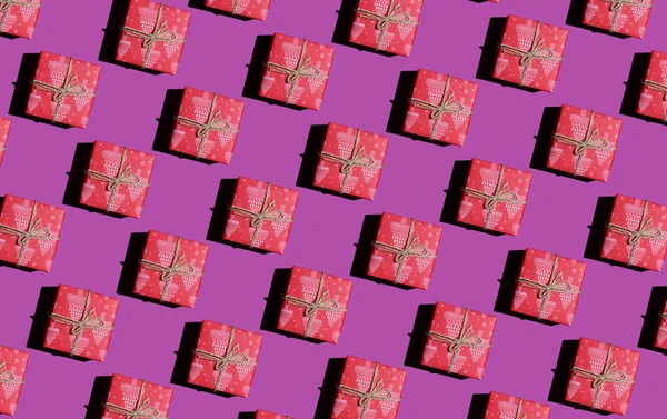 New Years gift in a red wrapper on a purple background. New year pattern — Stock Photo, Image