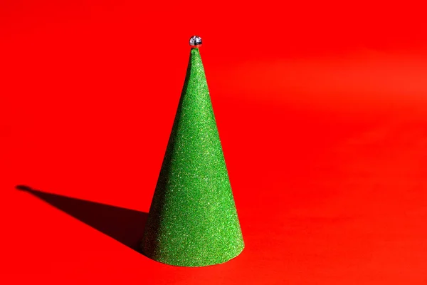 Árvore de Natal cone verde no fundo vermelho com sombra dura estilo pop art — Fotografia de Stock