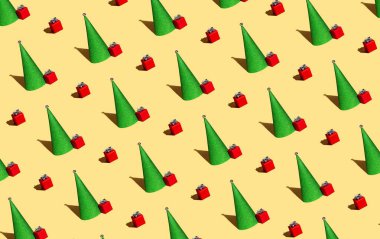 Yılbaşı ağacı ve sarı arka planda kırmızı hediyeler.