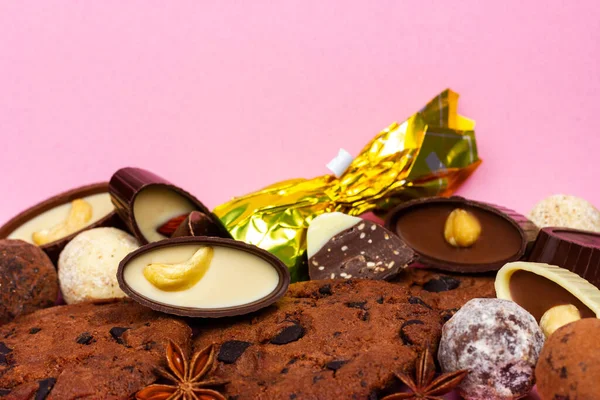 Cioccolatini, biscotti e tartufi su sfondo rosa. — Foto Stock