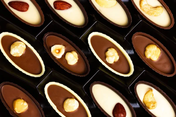 Cioccolatini con noci in una scatola. Vista dall'alto — Foto Stock