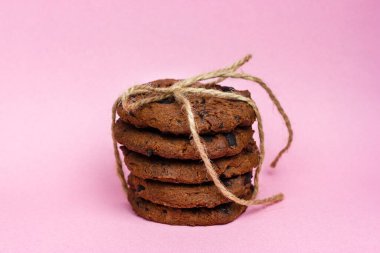 Pembe arka planda sicimle bağlanmış çikolatalı kurabiyeler..