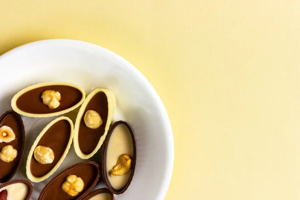 Cioccolatini su un piatto bianco. Cioccolato bianco e nero con noci — Foto Stock