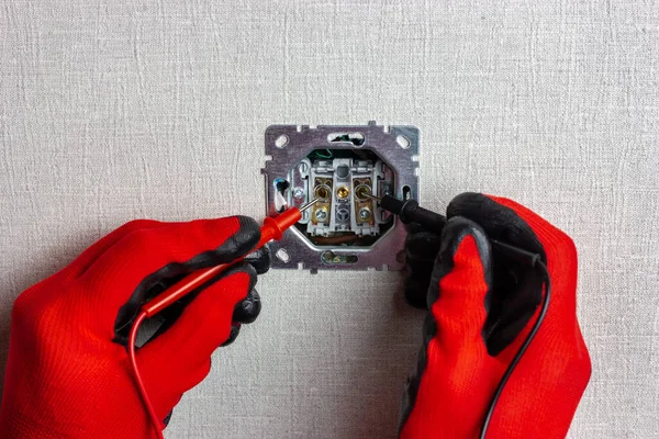 Bir elektrikçi çoklu metre kullanarak elektrik ağındaki voltajı kontrol eder.