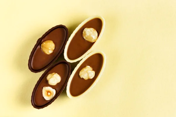 Quattro cioccolatini con noci su fondo giallo. Vista dall'alto. — Foto Stock