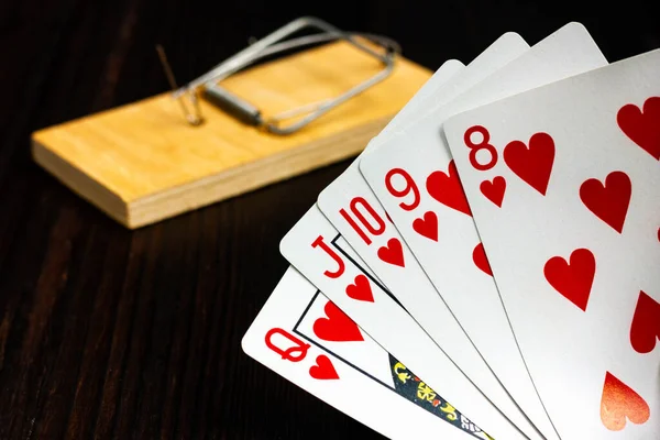 Pokerhanden är en kunglig flush. Spela kort på bakgrunden av en mus setrap. — Stockfoto