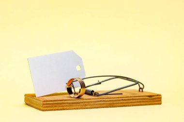 Alyansı olan fare kapanı ve mesaj için yeri olan beyaz kağıt etiket. Mantık evliliği, evlilik dolandırıcıları..