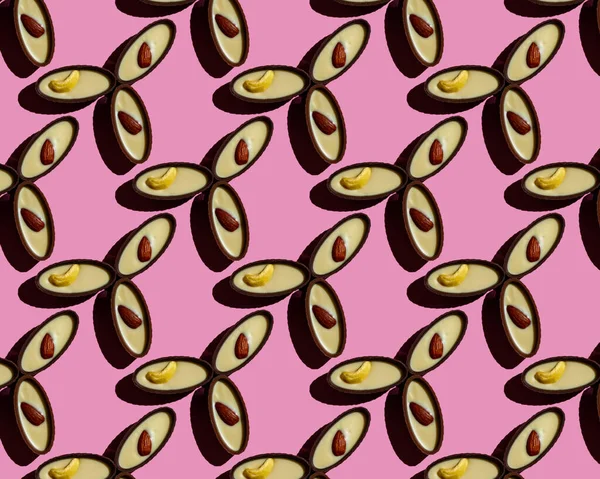 Nahtloses Muster von Schokoladenbonbons mit Nüssen auf rosa Hintergrund. — Stockfoto