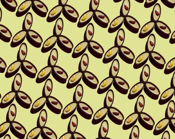 Čokoládové bonbóny na žlutém pozadí. Bezproblémový vzorec. Pohled shora. — Stock fotografie