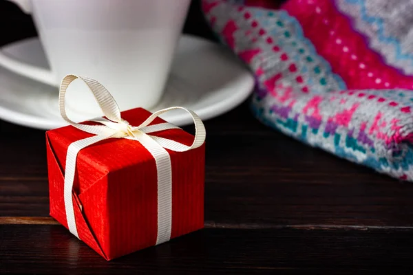 Cadeau rouge sur une table en bois sombre. Une surprise pour un être cher. Joyeux Noël, bonne année. Cadeau Saint Valentin. — Photo