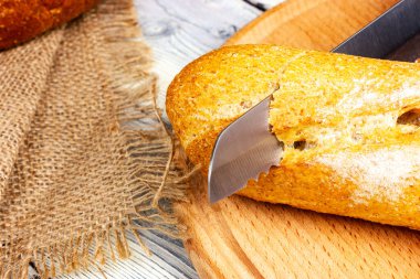 Ekmek bıçağı taze bir Fransız ekmeğini keser. Beyaz ekmek. Fırında ekmek kesiyorum. Fransız pastanesi.