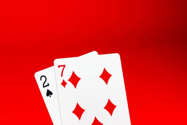 Mão de poker fraca. Jogando cartas em um fundo vermelho. Perder, azar. Perda de dinheiro. — Fotografia de Stock