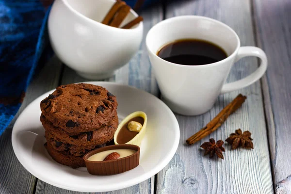 Šálek kávy, čokolády a sušenek na lehkém dřevěném stole. Snídaně v kavárně — Stock fotografie
