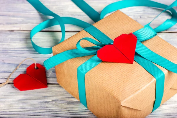 Cadeau enveloppé dans du papier artisanal et une petite note en forme de coeur. — Photo