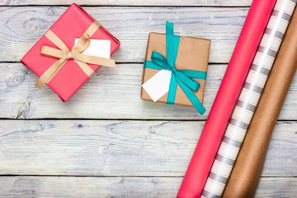 Emballage cadeau pour les vacances. Plusieurs cadeaux et papier d'emballage sur une table lumineuse. Festive Flat Lay dans le style provençal. — Photo