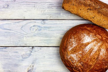 Hafif ahşap bir masada taze ekmek. Bedava yer. Provence tarzı. Ahşap bir masada çavdar ekmeği.