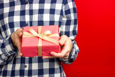 Kızın elinde bej bir kurdele olan pembe bir hediye. Sevdiğin birine hediye vermek.